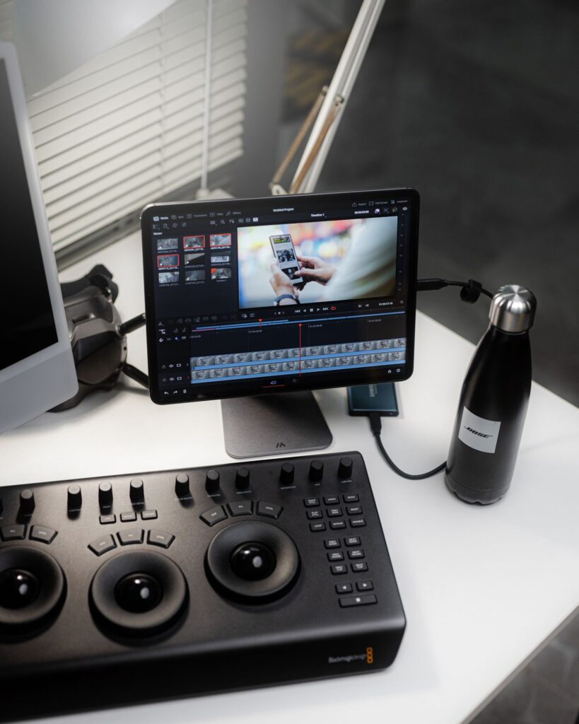 A tablet on a desk with video editing controls and accessories