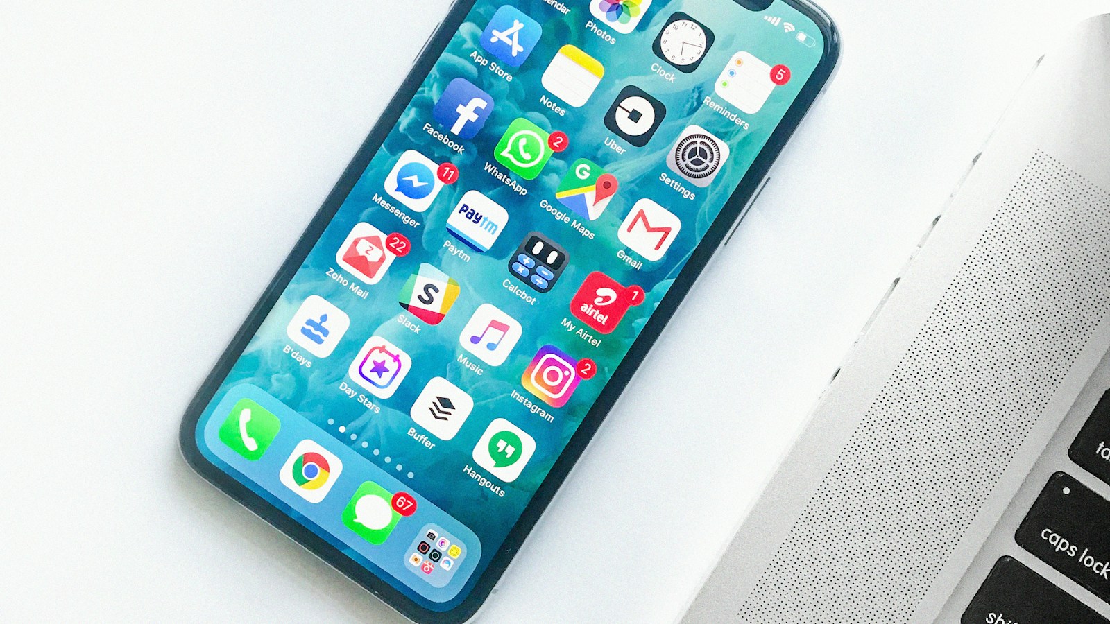 An older iPhone beside a laptop, illustrating everyday iPhone planning