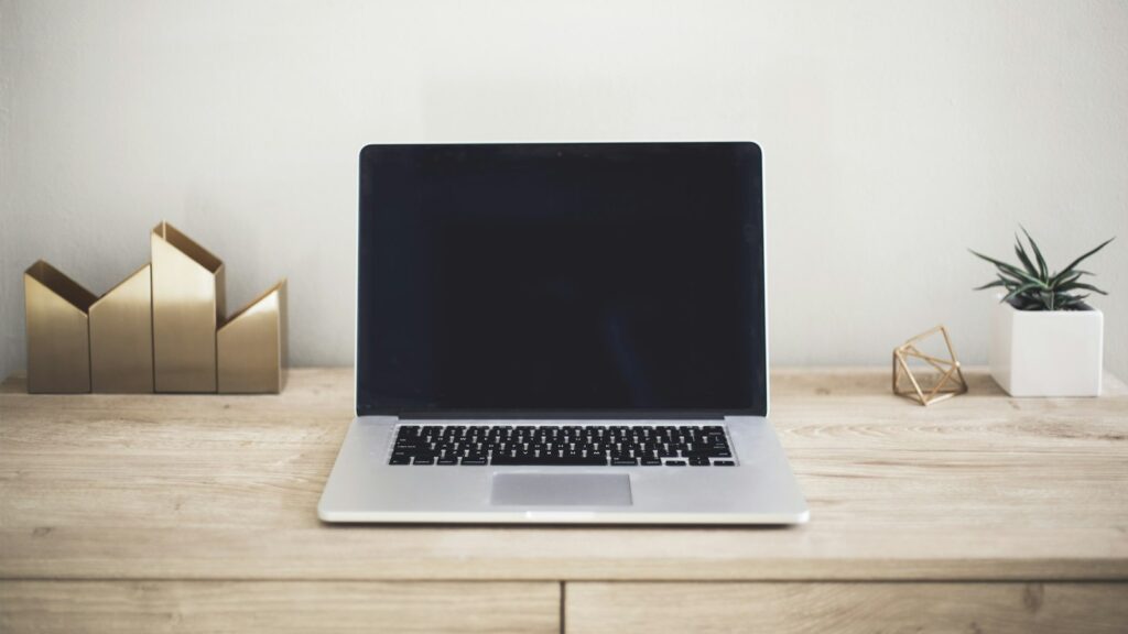 Laptop on a wooden desk illustrating a Safari extensions workspace